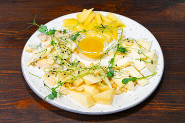 Delicious cheese and fruit platter served with honey sauce