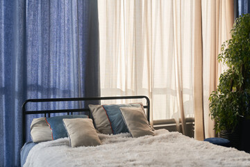There is a double bed and a blanket with pillows in the hotel room. Early morning. The concept of...