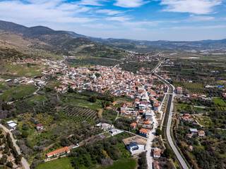 Aerial view of a village nestled in a valley surrounded by mountains and fields in Turkiye