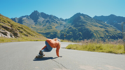woman skateboarding and making tricks between the curves on a mountain pass.
