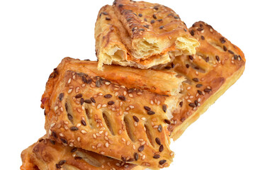 Puff pastry cake with filling and sesame seeds lies on a white background.