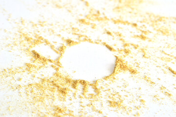 Ground mustard is scattered on a white background. A circle in the center of the powder.