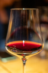 A glass of red wine on the table, with blur background in the restaurant