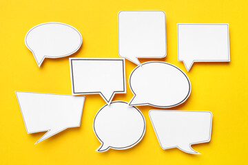 Blank speech bubbles on yellow background, top view. Space for text