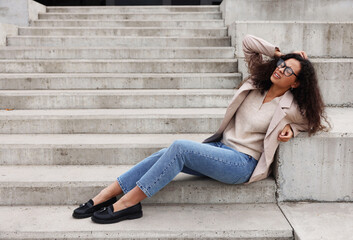 Woman with injured head on stairs outdoors after fall. Dangerous accident
