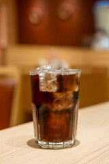 A glass of Cola on the table with bokeh background