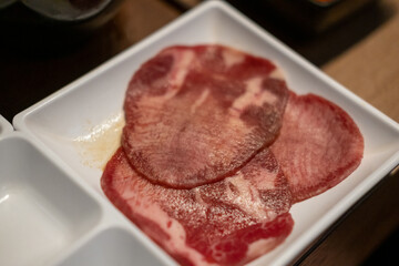 Korean Style Barbecue Grill BBQ rare beef tongue meat on plate