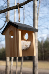 Wooden Birdhouse Hanging from Tree Branch in Serene Natural Environment, Perfect for Birdwatching and Enhancing Garden Aesthetic Appeal in Spring and Summer Seasons
