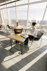 Two office workers working to together 