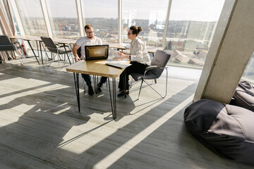 Two office workers working to together 