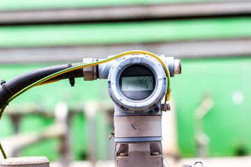 Close-up of chemical industrial pressure transmitter with digital display showing measurement...
