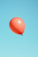 Fototapeta premium single red balloon floating against clear blue sky symbolizing inflation and economic pressure with ample copy space