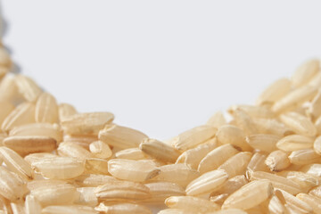 Close up of uncooked jasmine rice grains on white background with text space.