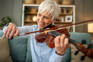 Woman playing the violin while relaxing on her sofa