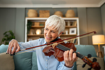 Woman playing the violin while relaxing on her sofa