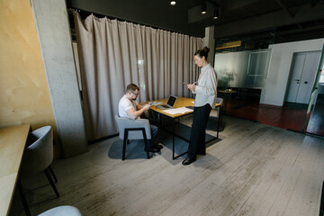 Two office workers working to together 