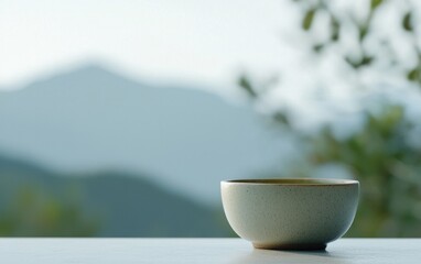 Speckled Teacup on White Surface Against Mountain View