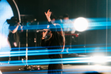 Woman worshipping, singer at concert
