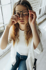 Poor vision. Young woman with glasses, girl with poor vision on white background