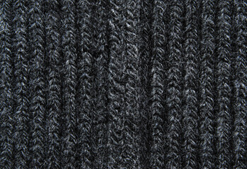 Dark gray braid knit pattern close up with a seam in the center as background