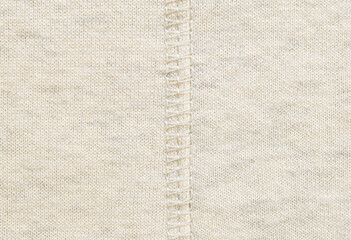 Fototapeta premium Soft beige cotton melange jersey fabric with a overlock seam detail in the center texture or background