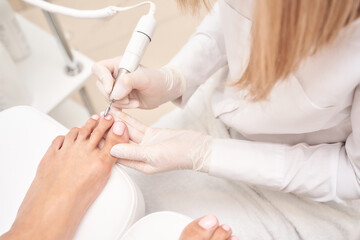 Female caucasian adult receiving professional pedicure treatment at nail salon.