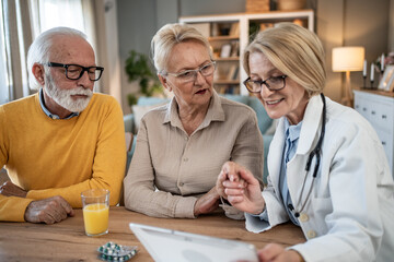 Obraz premium Senior couple discussing medical information with doctor on tablet