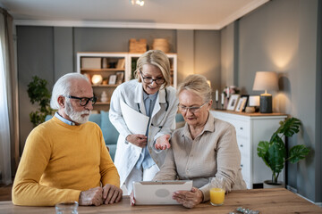 Female doctor comforting senior couple at home during home visit