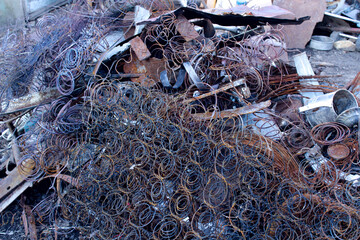 Close-up of a rusty pile of scrap metal springs, discarded outdoors