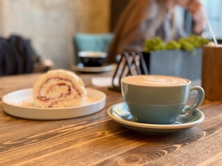 A Delightful and Delicious Coffee Alongside an Amazing Dessert Experience Awaiting You. A beautifully crafted latte alongside a delicious pastry resting on a warm wooden table, ideal for cafe goers