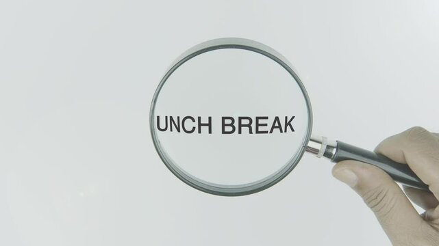 Lunch break text or word highlighted by a magnifying glass in a hand on a white background, symbolizing a pause during work or daily activities for eating, rest, and recharging