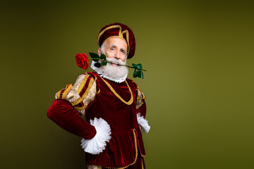 Elderly man in royal costume with rose showcases elegance and humor in modern representation of historical nobility.
