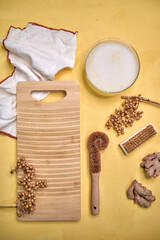 top view of the washing board and natural brushes on a yellow background, eco-friendly washing