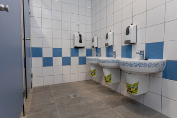 A modern public restroom design featuring dual sinks and efficient hand dryers for convenience