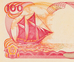 Fragment of a 100 rupiah banknote from Indonesia, depicting the Pinisi Boat. Paper money from...