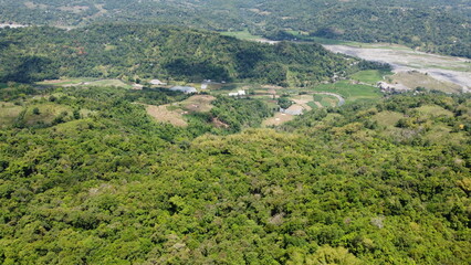 Fototapeta premium Lush Green Hills and Agricultural Fields in a Rural Valley