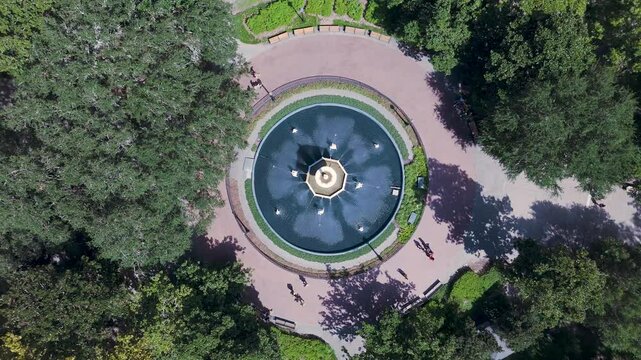 4K aerial footage of the iconic fountain in Forsyth Park, Savannah, GA. Smooth drone views capture lush greenery, historic charm, and serene park atmosphere.