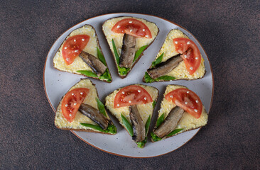 Sandwiches with sprats, tomatoes and green onions in shape of mushrooms