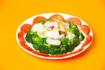 Fried Squid with Broccoli served in plate isolated on orange background side view of hong kong food