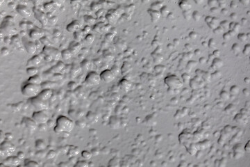 Close-up of light grey painted metal, highlighting surface textures with subtle variations in tone. Ideal for background and texture