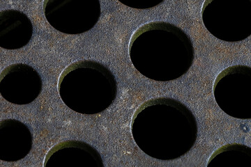 Close-up of rusted metal grates, showcasing their aged texture and intricate pattern of corrosion