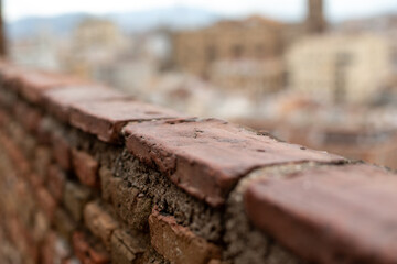 Close-up of an old brick wall with a blurred city backdrop