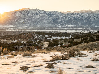 Utah Snow covered mountain range at sunrise with residential area below Heber UT