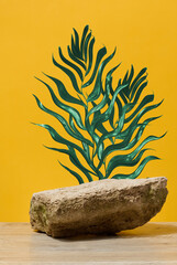 Stone on yellow background with green branch, stage for cosmetics and products demonstration