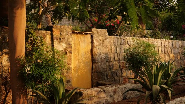 A Serene Garden Waterfall featuring a Natural Stone Wall, creating a beautiful outdoor space