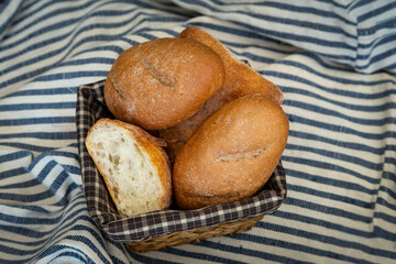Golden, crispy, a delightful harmony of fresh-baked goodness. Fresh bread on stripped fabric. 