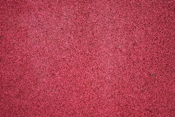 Fototapeta premium Red sports field rubber coating close up. Playground paving background texture.