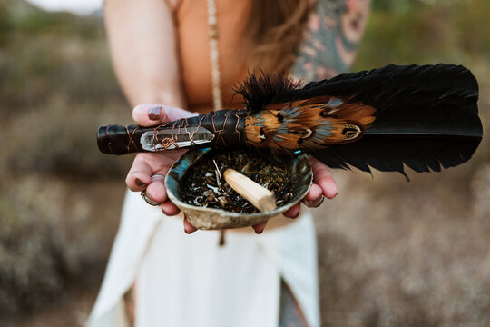 Woman holding flower and shell and medicinal herbs