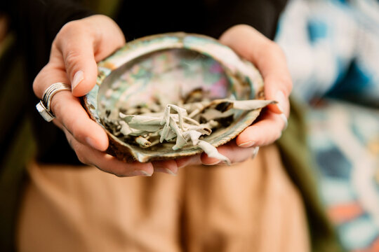 Woman holding a shell with medicinal herbs