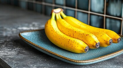  a bunch of ripe, yellow bananas sitting on top of a blue plate on a table The background is slightly blurred, giving the focus to the plate and the bananas